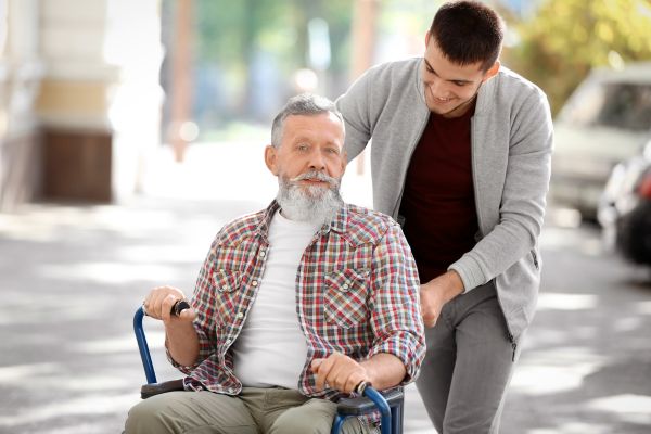 Young Caregiver Walking with Senior Man Young Caregiver Walking with Senior Man